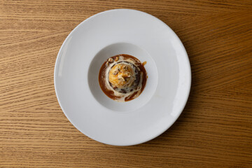 Top view of delicious dessert with ice cream and caramel sauce served on a plate