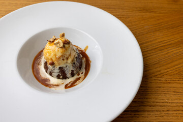 Delicious dessert with ice cream and caramel sauce served on a plate
