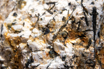 Intricate details of granite stone, showcasing a blend of white, black, and brown minerals. The rough texture and varied coloration