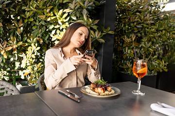 Young woman snapping picture of her meal at outdoor café