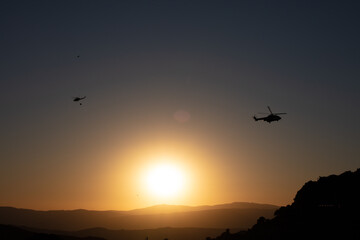 Helicopters flying at sunset in Casares mountain landscape. Casares, Andalusia Spain. 5 September 2025.