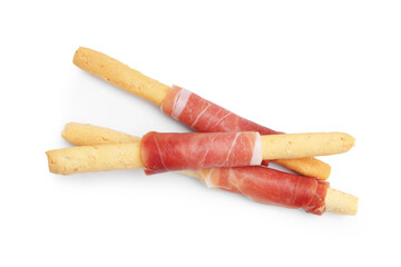 Delicious grissini sticks with prosciutto isolated on white, top view