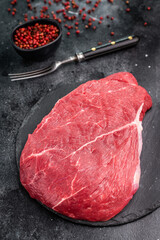 Fresh raw top sirloin steak, beautifully marbled and ready for grilling, perfect for meat lovers seeking quality. black background. top view