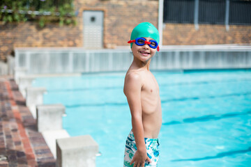Lap pool lanes glistening under bright sun on brick-paved deck with metal railing, starting blocks