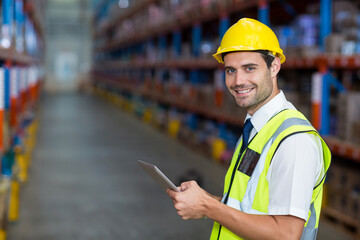 Warehouse supervisor inspecting metal shelving racks and recording inventory on tablet in aisle