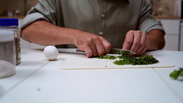 A chef professionally prepares a fresh vegetable salad, chopping potatoes, eggs, and greens. Dynamic cooking process showcasing culinary skills and healthy food preparation
