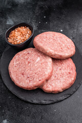 Fresh raw beef meat patty ready for grilling, perfect for homemade burgers and delicious family meals.black background. top view
