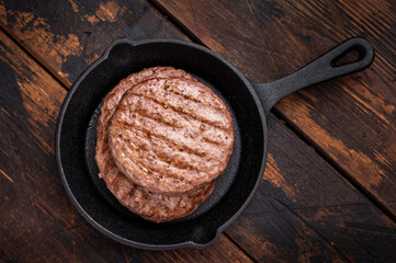 Deliciously charred grilled meat burger patty on the grill, perfect for satisfying cravings at any cookout. wooden background. top view