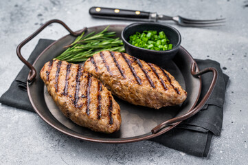 Close up of succulent grilled kofta kebabs or kebaps, showcasing rich spices and a tantalizing golden-brown crust. grey background. top view