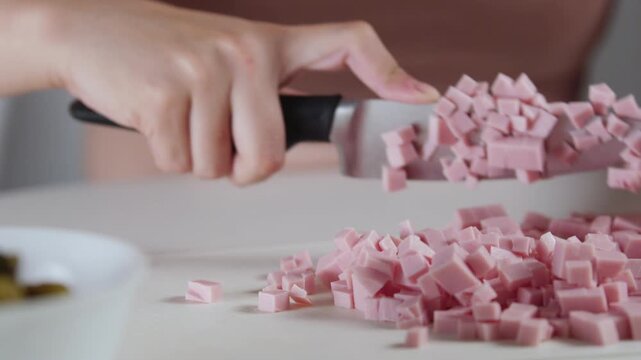 A chef professionally prepares a fresh vegetable salad, chopping potatoes, eggs, and greens. Dynamic cooking process showcasing culinary skills and healthy food preparation
