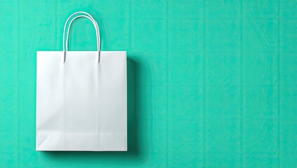 Blank white paper shopping bag against a teal background (1)