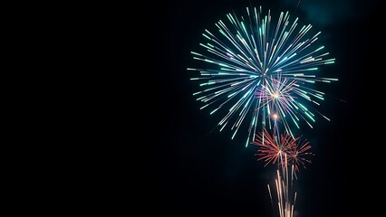 Fototapeta premium Vibrant fireworks exploding in a night sky, creating colorful sparks and dramatic light trails.