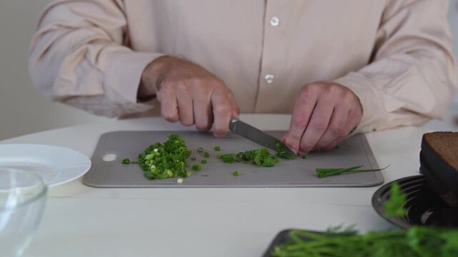 A chef professionally prepares a fresh vegetable salad, chopping potatoes, eggs, and greens. Dynamic cooking process showcasing culinary skills and healthy food preparation