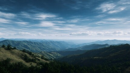 Fototapeta premium Expansive panoramic view of rolling green hills and distant mountains under a vast blue sky with scattered clouds