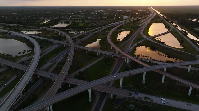 Aerial view of the Sawgrass Interchange with a network of roads connecting urban areas, while the sunset reflects off the water, Sunrise, Florida, USA.