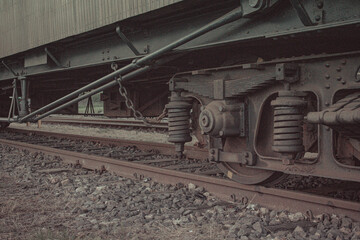Close up view of vintage train suspension and wheel on rusty railway track