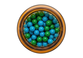 Isolated overhead view of green and blue round candies inside an amber glass jar
