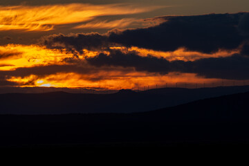 Majestic Sunset Over Wind Turbines on Horizon