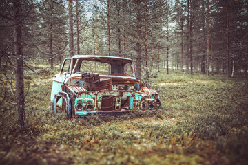 Abondened rusty car in the middle of a forest in Finland