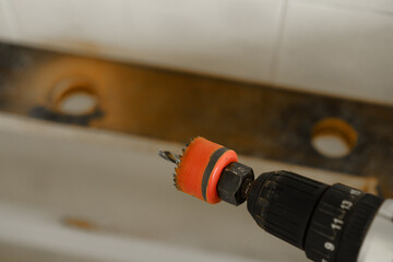 Power drill with hole saw attachment used for home improvement task in a bathroom renovation project