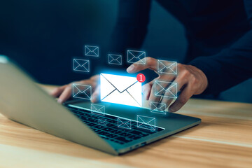 Businessman using laptop with digital email icons and notification alert symbolizing online communication, email marketing, messaging service, and modern digital business connection.
