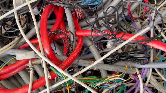 Old electronic consumer goods placed in a bin at a local council waste collection centre for recycling or disposal. 
A confusion of cables and wires. 

