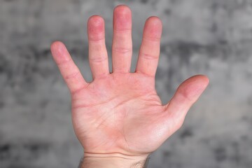 Handout of an adult male showing an open palm against a textured background exploring the essence of human connection and tactile communication expressing authenticity and openness