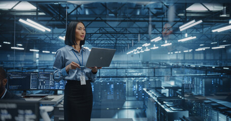 Portrait of a Asian Female Data Center Specialist Analyzing System Performance on a Laptop, Optimizing Cybersecurity Protocols in a High-tech Facility. Developer Monitors Real-time Data on Computer