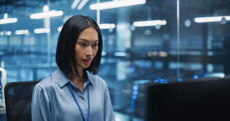 Asian Software Developer Analyze System Performance Metrics on a Computer Inside a Modern Data Center. Young Female Manager Ensuring Efficient Operations for Critical Infrastructure