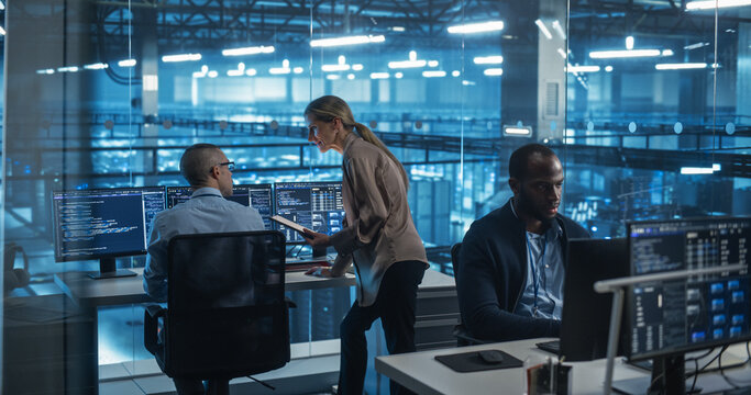 Diverse Team of Developers Working on Computers in a Modern Office in a Data Center Facility. Team Analyzing Data and Optimizing Systems. Female Manager Having a Conversation with a Colleague
