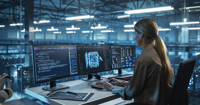 Female Software Engineer Works on Developing a Visual AI Model, Carefully Adjusting Lines of Code. Specialist Sitting in Front of Three Computer Monitors in a Glass-Enclosed Modern Data Center Office