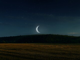 Crescent moon rising over the hill. Moon in the evening sky, astronomical landscape. Dreamy view.