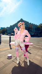 Playful stylish woman with pink curlers and retro outfit posing with iron outdoors. Concept of lifestyle parody, creative branding, retro glamour, digital art visuals for posters.