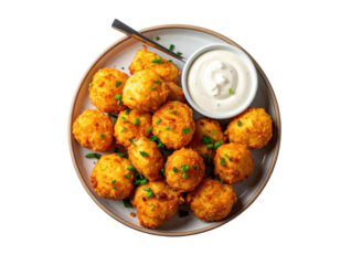 Crispy, golden-brown bite-sized balls, garnished with chives, served on a plate with a side of creamy sauce