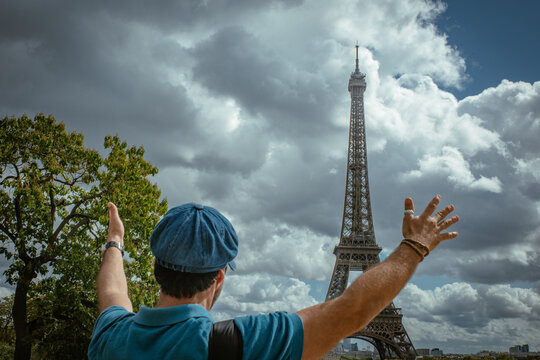 Turista disfrutando de la Torre Eiffel en Par&iacute;s, con boina azul parisina y sonrisa alegre.