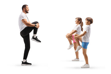 Full length profile shot of children stretching knees with a sports coach
