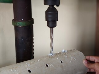 making holes in pipes using a hand drill