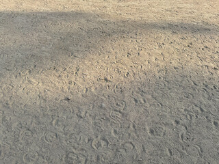 sand texture background with foot steps on the beach. empty landscape, close up of sand with sun rays
