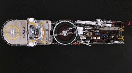 Nyack, United States - 16 September 2025: Aerial view of a large vessel with a helipad and complex machinery, cutting a stark figure against the dark water.