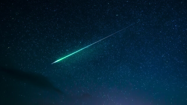 Green meteor streaking over mountain range at night.