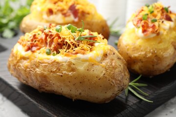 Tasty stuffed baked potatoes on table, closeup