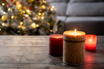 Red Christmas candles with holiday lights and christmas tree in background. Copy space