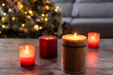 Red Christmas candles with holiday lights and christmas tree in background. Copy space