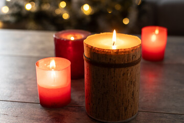 Red Christmas candles with holiday lights and christmas tree in background. Copy space