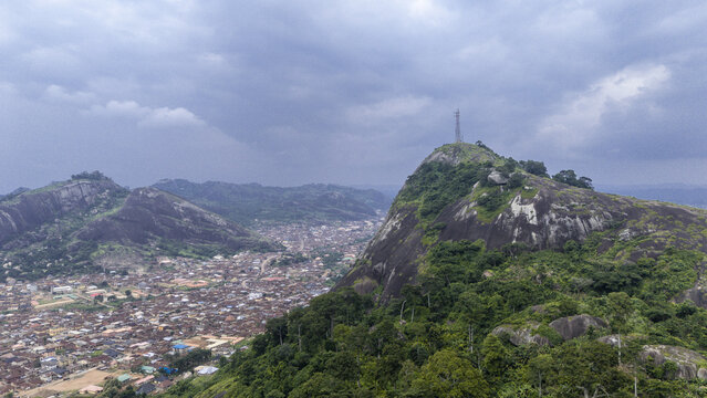Aerial view of the majestic Idanre Hills tower over the town below, the rocky outcrops contrasting with the lush green vegetation, Ida really, Ondo, Nigeria.