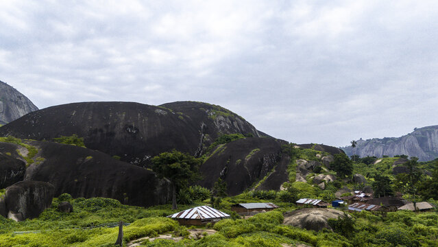 Aerial view of the ancient Idanre Hills rise majestically, their dark, rocky forms contrasting with the vibrant green vegetation, Ida really, Ondo, Nigeria.
