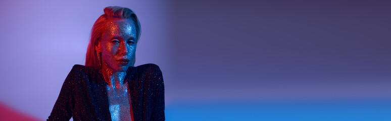 Young beautiful woman shines with glitter in vibrant studio scene