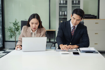 Business team analyzing documents, graphs, and data with a laptop, tablet, and smartphone. Collaboration, strategy, and success.