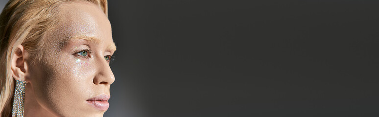 Young blonde woman shines with glitter in a glamorous studio setting