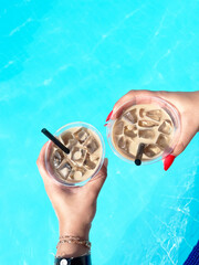 sitting by the hotel pool in the summer with glasses of cold iced coffee, Summer vacation concept